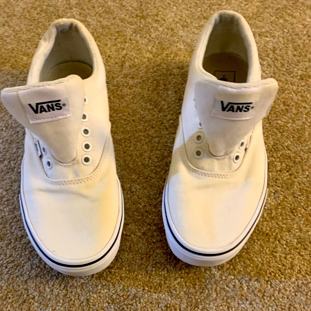 All white Vans with navy blue trim.